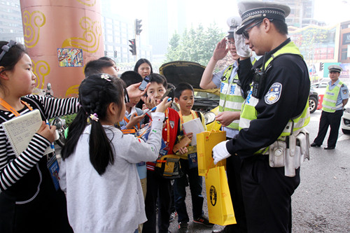 在紅旗河溝流動警務車執(zhí)勤點，小記者們送上了慰問品，并積極采訪交警人員。新華網發(fā)（喻盾 攝）_副本.jpg